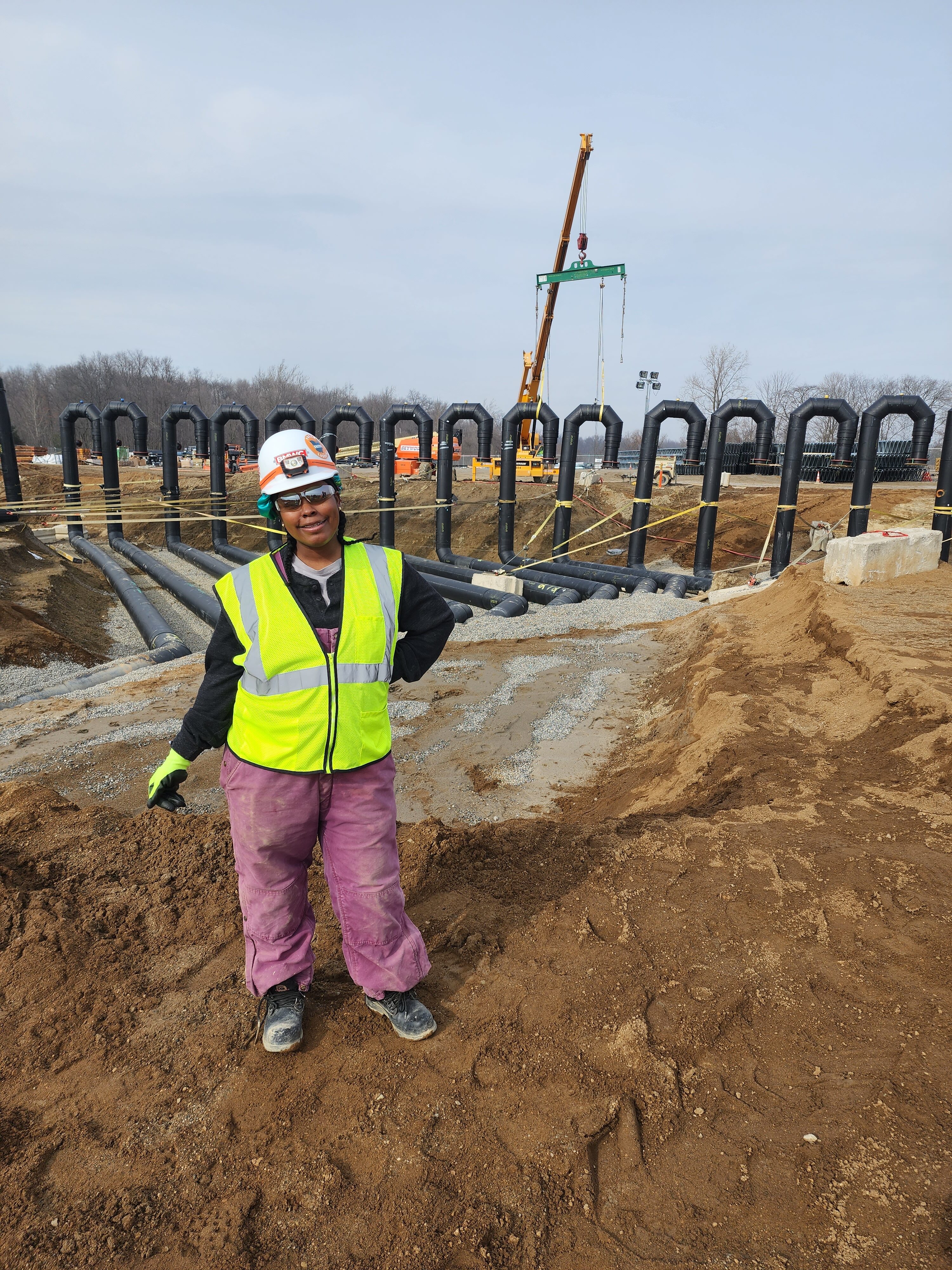 asia washington posing in front of crane on job site. 