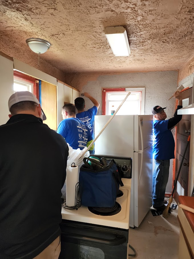 four men interior painting gray walls 