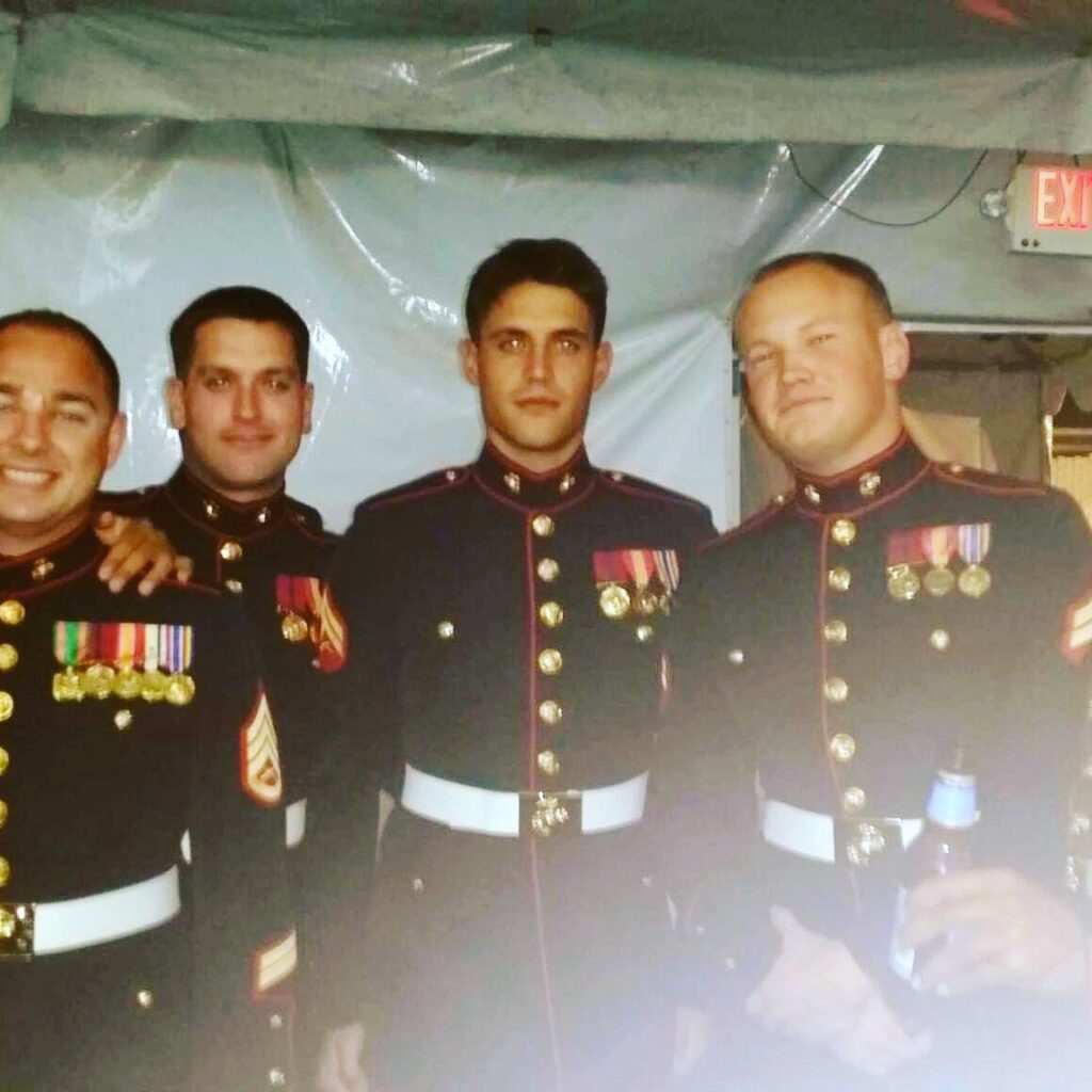 Group including Corporal Shane Tate from USMC posing for picture dressed in uniform with medals 