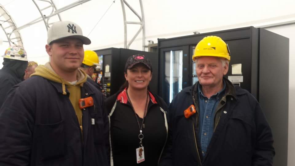 three generations of construction industry workers posing with hard hate safety gear safety helmet yellow 